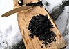 black adhesive substance on the wooden log