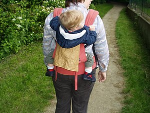Deutsch: Ein Kind auf dem Rücken der Mutter in...