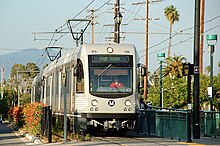 A Metro Gold Line train passes a community in Highland Park.