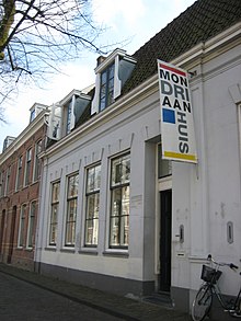 A historic urban house with a sign saying "Mondriaanhuis"