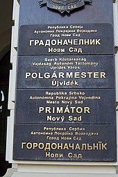 Multilingual sign outside the mayor's office in Novi Sad, written in the four official languages of the city: Serbian, Hungarian, Slovak, and Pannonian Rusyn Novi Sad mayor office.jpg