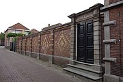 De tuinmuur, ontworpen door Posthumus Meyjes, gezien vanuit de H.J. Schimmelstraat