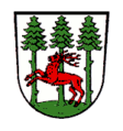 Markt Konnersreuth In Silber auf grünem Boden nebeneinander drei grüne Tannenbäume, vor denen ein roter Hirsch springt.