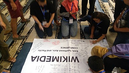 closing activity:participants writing on the conference tarpaulin