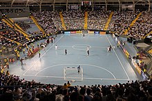 This image is showing a large crowd at a Futsal game with the payers ready to start.