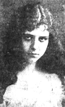 Portrait of a young girl with long curly hair in a lace dress