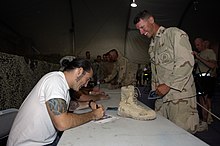 US Navy 080712-N-6477M-654 Steel Worker 2nd Class Cody Bauer, assigned to Naval Mobile Construction Battalion (NMCB) 3 Det. 4, meets SEVENDUST, a recording artist from Atlanta, Ga., after a live performance for the troops At Ba.jpg