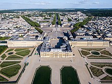 Photo aérienne d'un château et de son jardin avec la ville en arrière-plan