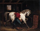 Oil painting of a horse groom, with his back to the viewer, brushing a large, white horse that is pawing the ground and turning to look at the groom.