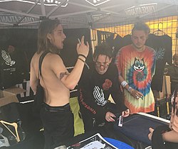 Chase Atlantic jakamassa nimikirjoituksia Warped Tourilla 2018. Vasemmalta oikealle: Christian Anthony, Mitchel Cave, Clinton Cave.