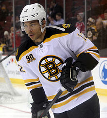 Iginla states intently into the distance as he skates near a net.