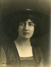 A young white woman with dark eyes, wearing a hat with a wide brim. Her expression might be described as anxious or sad.