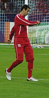 Фотография мужчины в красной футбольной форме ассоциации.