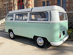 Un Volkswagen Combi dans une belle livrée vert d’eau à toit blanc.