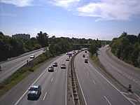 Die Preetzer Chaussee, ehemals beidseitig baumbestandene, zweispurige Allee, teilt als Bundesstraße 76 (B76) Elmschenhagen in E.-Nord (rechts) und E.-Süd (links); Blick nach Westen zum „Elmschenhagener Kreisel“ Richtung Kiel (Aufnahme Juni 2008).