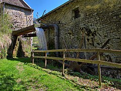 Le canal des meuniers et les restes d'une roue à aubes.