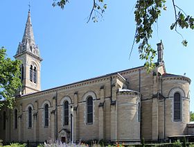 Église depuis le prolongement de sa nef et jusqu'à son chevet selon un angle de trois quarts arrière.