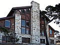 Фотография Merrill Hall в конференц-зале Asilomar, высокого и широкого остроконечного здания из дерева и камня.