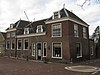 Pand op de hoek van de Biezenpoortstraat, bestaande uit een middengedeelte onder een schilddak, evenwijdig aan de straat, geflankeerd door twee hoger opgetrokken hoekpartijen onder schilddaken, die loodrec