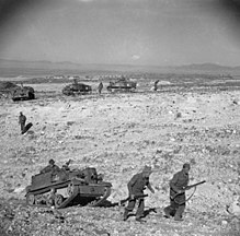 Infantry and carriers of the Grenadier Guards, advance over difficult terrain near the Kasserine Pass, 24 February 1943. The British Army in Tunisia 1943 NA880.jpg