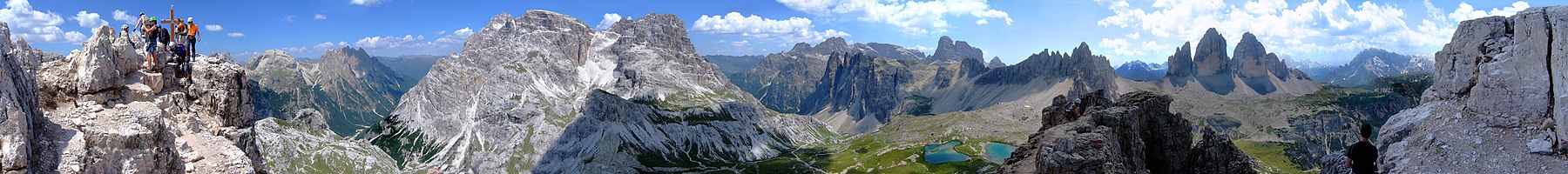 Panoramakilátás a Toblinger Knoten csúcsáról. Baloldalt (északnyugaton) a Haunold-csoport, középen (kb. keleten) a Bödenalpe (Schusterplatte/Innichriedkofel), tovább jobbra (délkeleten) a Sexteni-Dolomitok (Elferkofel, Zwölferkofel), majd délen a Paternkofel és a Drei Zinnen három csúcsa, a jobb szélen (délnyugaton) a Monte Piana fennsíkja és mögötte távolabb a Cristallo hegycsoportja.