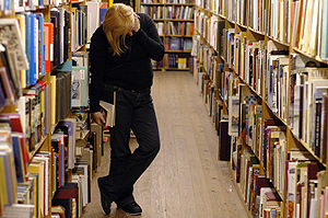 Woman browse books on an unknown library.