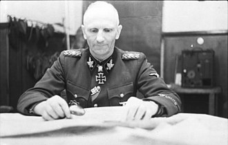Gille ještě v hodnosti SS-Gruppenführera během jara roku 1944 v Sovětském svazu. U jeho krku můžeme vidět vysoce cenněný rytířský kříž železného kříže s dubovými ratolestmi a meči.