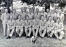 Portrait officiel de William Hopton Anderson assis avec le personnel, les étudiants et le bouledogue mascotte de l'école d'état-major de la RAAF.