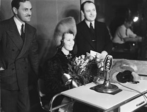 Lily Pons, cantatrice française, assise devant un micro, entourée de deux animateurs à la station radiophonique C.K.A.C.