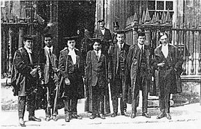 Ramanujan (centre) and his colleague G. H. Hardy (rightmost), with other scientists, outside the Senate House, Cambridge, c.1914-19 RamanujanCambridge.jpg