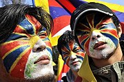 Tibetan flags painted on the faces of Tibetan demonstrators
