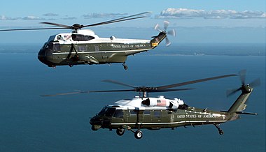 Heraldiskt vapen för HMX-1 samt de två helikoptertyper som skvadronen flyger USA:s president med: överst VH-3D (en variant av "Sea King") och nederst VH-60N (en variant av "Black Hawk").