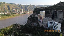 The Yellow River is the natural provincial border between Wubu, Shaanxi (right) and Liulin, Shanxi (left), both being the heartland of Jin Chinese language. The Taiyuan-Zhongwei-Yinchuan railway ran across the bridge. Yellow River bridge connecting Wubu and Liulin.jpg