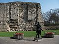 Statwa tal-Imperatur Trajan quddiem il-fdalijiet ta’ ħajt ta’ żmien Ruman fit-Tower Hill, London (Londra/Londres).