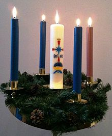 An Advent wreath with three blue candles and one rose candle surrounding the central Christ Candle Adventwreath.jpg