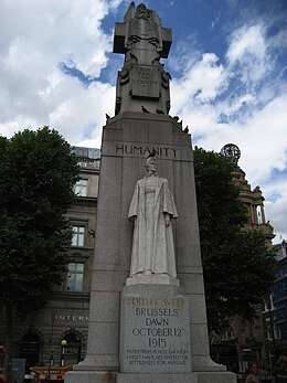 A marble statue of Edith Cavell in nurse's uniform backed by a large granite column, surmounted by a figure representing Humanity