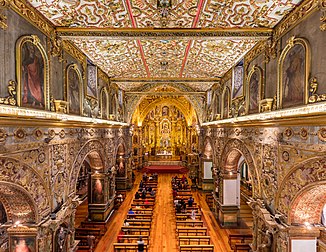 Vista da nave principal da igreja de São Francisco, Quito, Equador. O templo católico foi concluído no século XVII e é o maior conjunto arquitetônico de origem colonial entre as estruturas históricas da América Latina. A igreja também se destaca pela fusão de diferentes estilos arquitetônicos, uma vez que a sua construção durou 150 anos. (definição 7 353 × 5 690)