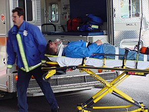 Medical personnel using a stretcher-type gurney.