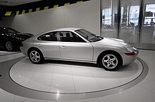 Prototype de la berline Porsche 989 au musée Porsche, vu de profil. Le véhicule est peint en gris.