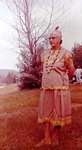 Photograph of Sarah Lavalley in Indigenous clothing standing outdoors