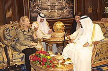 Снимка на среща на държавния секретар Клинтън с краля на Саудитска Арабия Абдула. Тя е седнала отляво, той отдясно. Техните преводачи са на заден план.