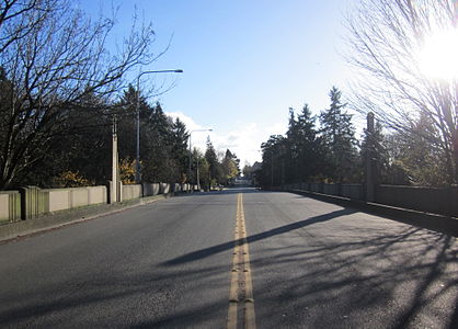 A street-level view of 15th Avenue NE as it continues along the Cowen Park Bridge.