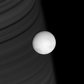 Enceladus backdropped by Saturn's ring shadows...