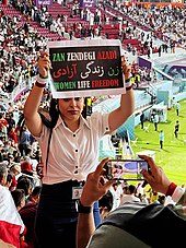 An Iranian fan showing a banner with "Woman, Life, Freedom" slogan Iran national team fan 01.jpg