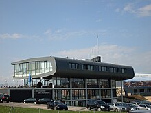 Le bâtiment principal de l'aéroport avec la tour, la douane et le restaurant.