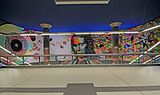 Photo couleur d'une fresque murale dans une station de métro. Elle figure le visage d'un jeune homme partiellement composé de triangles de diverses couleurs.