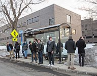 люди ждут автобуса на закрытой автобусной остановке в холодную погоду