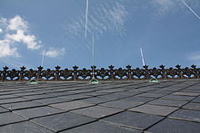 Photographie en contre-plongée des ardoises carrées du toit