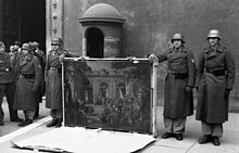 German soldiers of the Hermann Goring Division posing near the main entrance of Palazzo Venezia showing a painting taken from the National Museum of Naples Picture Gallery Bundesarchiv Bild 101I-729-0001-23, Italien, Uberfuhrung von Kunstschatzen.jpg