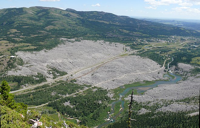 Un champ de débris vu de haut traversé par une route et un chemin de fer.